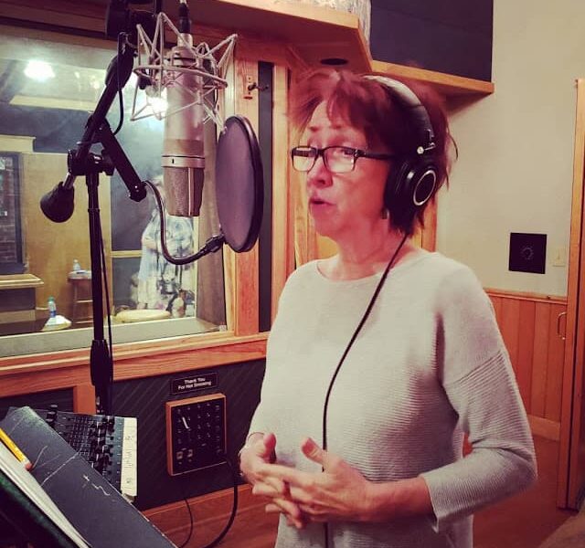 Judy Rodman singing into recording studio microphone